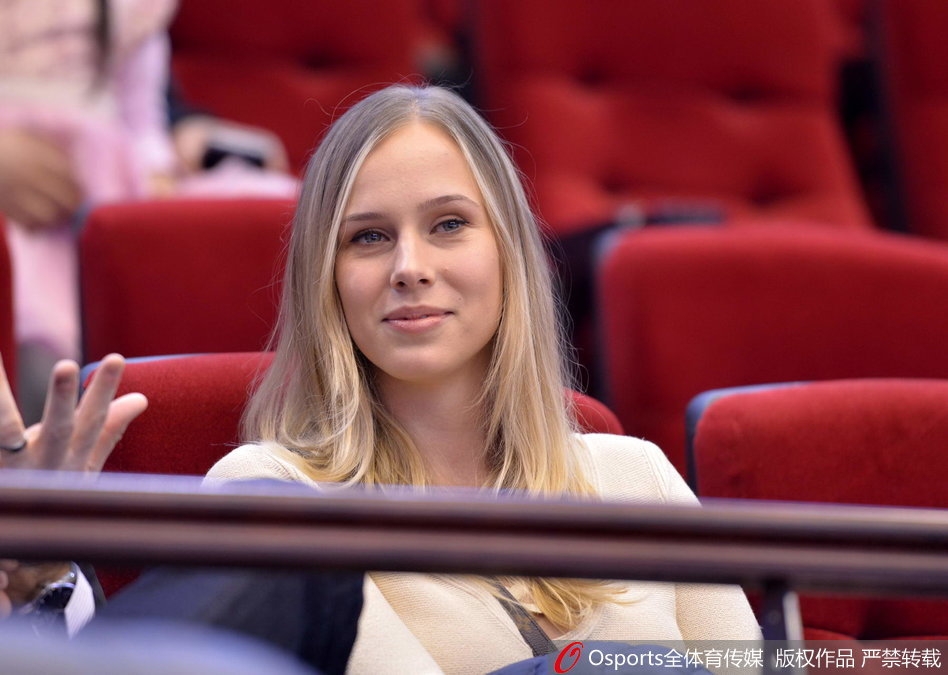 她似乎在为场上的某个精彩回合振臂高呼,嘴角洋溢着灿烂的笑容,精致的侧颜在球场灯光的映照下显得格外迷人。