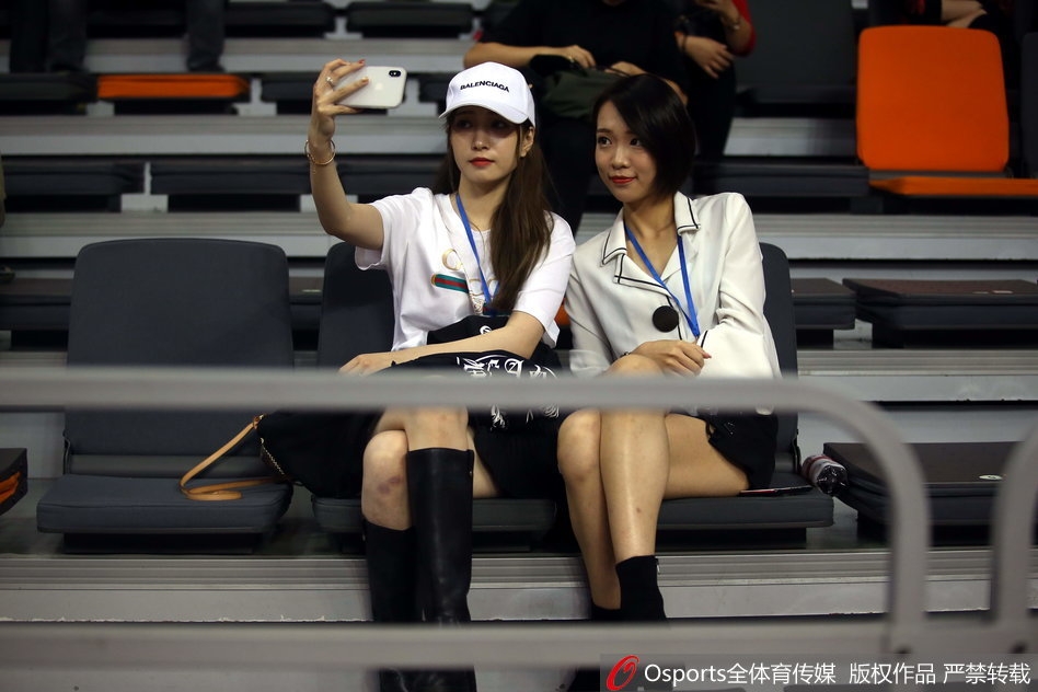 一位戴着时尚眼镜的美女球迷神情专注,双手轻轻托腮,在激烈的比赛间隙流露出别样的恬静与柔美。