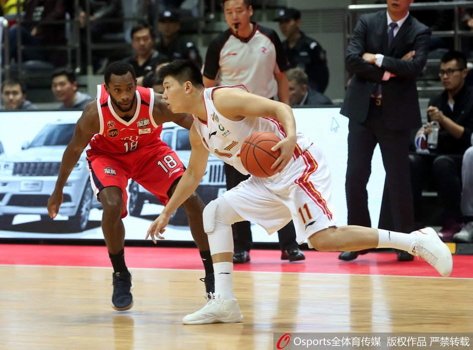 八一队核心后卫田宇翔在对方两人的夹击缝隙中强行突破，眼神坚毅，嘴角挂着不服输的倔强。