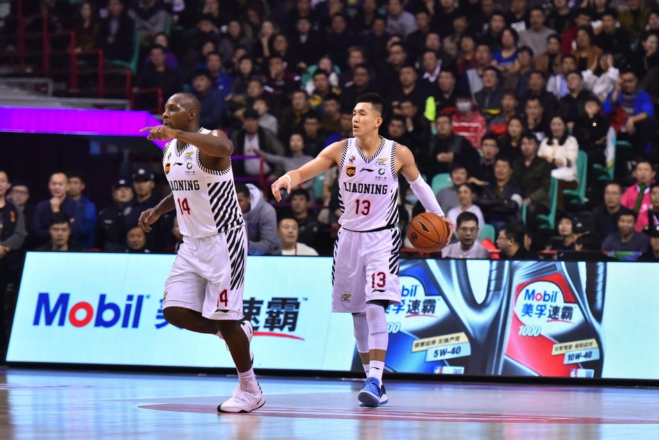 郭艾伦在两人夹击防守下高高跃起,试图完成一次难度极高的上篮,他身前的防守队员奋力起跳封盖。