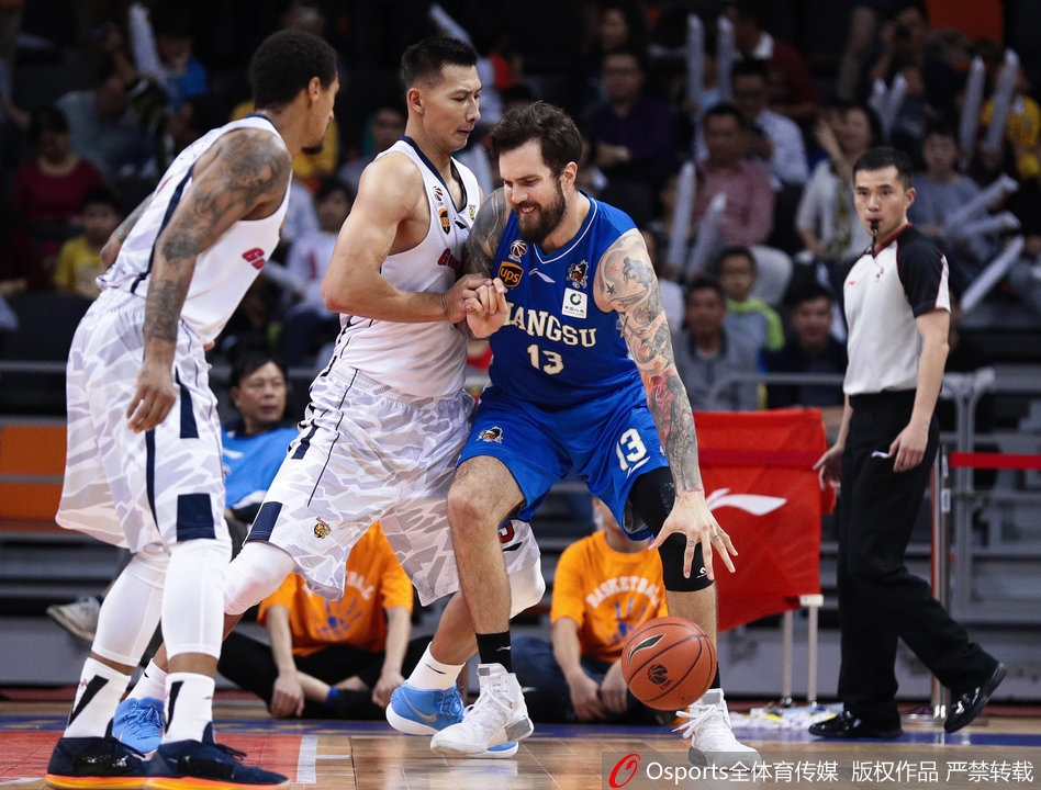 易建联叉腰低头站在篮下,眼神中充满不甘,身后是欢庆胜利的江苏球员,巨大的反差让人感受到竞技体育的残酷。