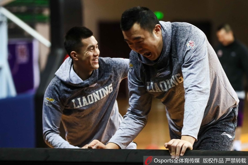 对抗训练结束后，两人并肩坐在场边休息，郭艾伦侧身对着大韩手舞足蹈地讲着什么，韩德君则侧耳倾听，画面充满了兄弟般的信任与温馨