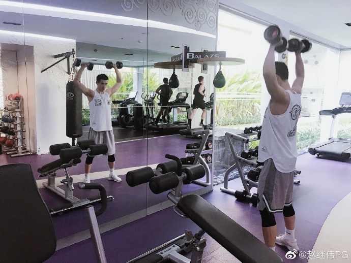 完成训练后的赵继伟对着镜头露出自信微笑，背景的度假风光与他刚毅的脸庞形成对比，诠释了真正的劳逸结合。