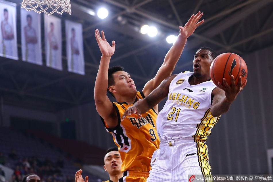 山西队外援布朗运球疾走，眼神如炬凝视前场队友，正欲送出一记穿透北控防线的关键传球。