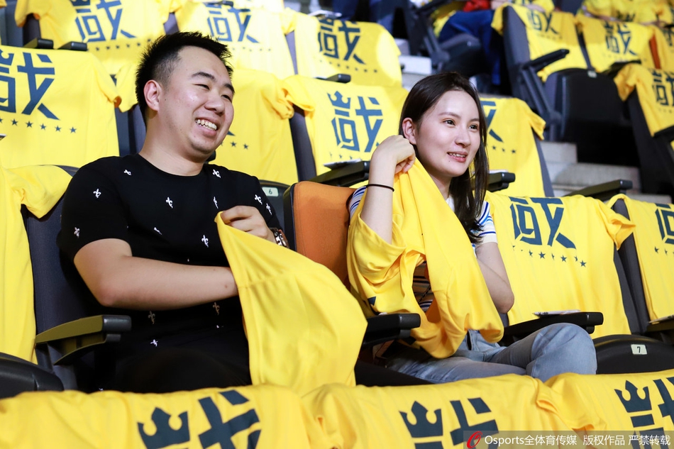 小将徐杰在黄色海洋的包围中持球突破，眼神坚毅，黄衣球迷们纷纷起身，挥舞双臂，为这位年轻后卫的每一次冲锋呐喊助威。