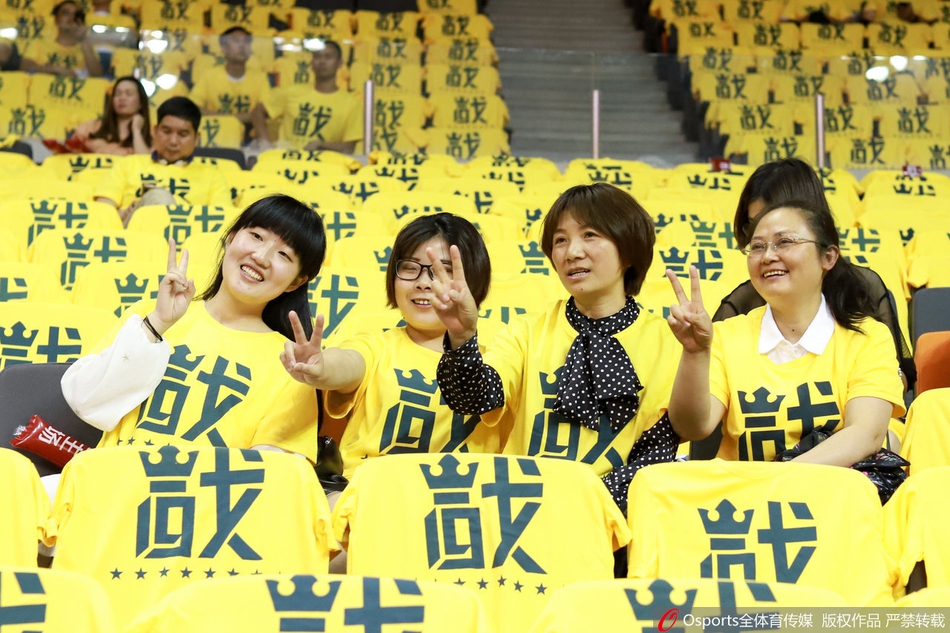俯瞰东莞篮球中心，万人齐穿黄色助威服，座椅与人群交织成一片壮阔的金色波涛，气势磅礴如海啸前夕。
