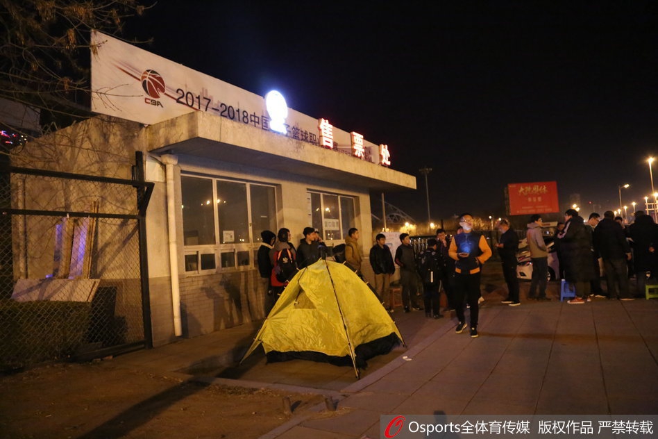 灰色的帐篷在空旷的广场上格外显眼，四位大学生球迷蜷缩在狭小的帐篷空间内，用保温杯里的热水抵御着凌晨的刺骨寒风。