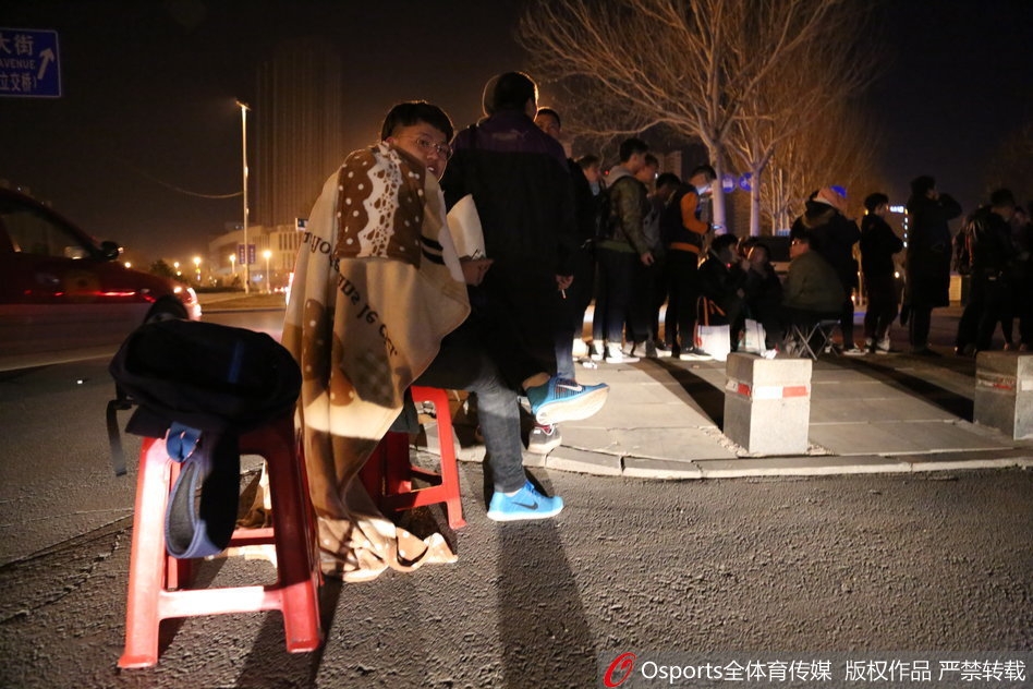 深夜的辽宁省体育馆外，路灯昏黄，数百名球迷排成的长队宛如长龙，蜿蜒曲折一眼望不到头，大家裹紧棉衣翘首以盼。