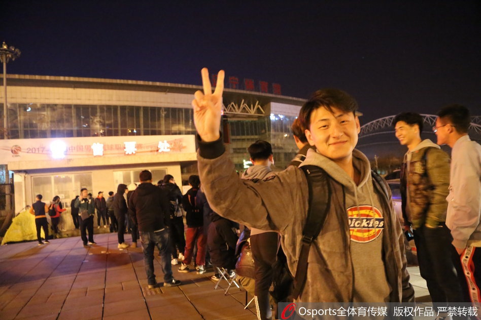 排队的人群中，几名年轻球迷实在困倦难耐，索性坐在自带的防潮垫上背靠背小憩，即使睡着了手里还紧紧攥着准备买票的证件。