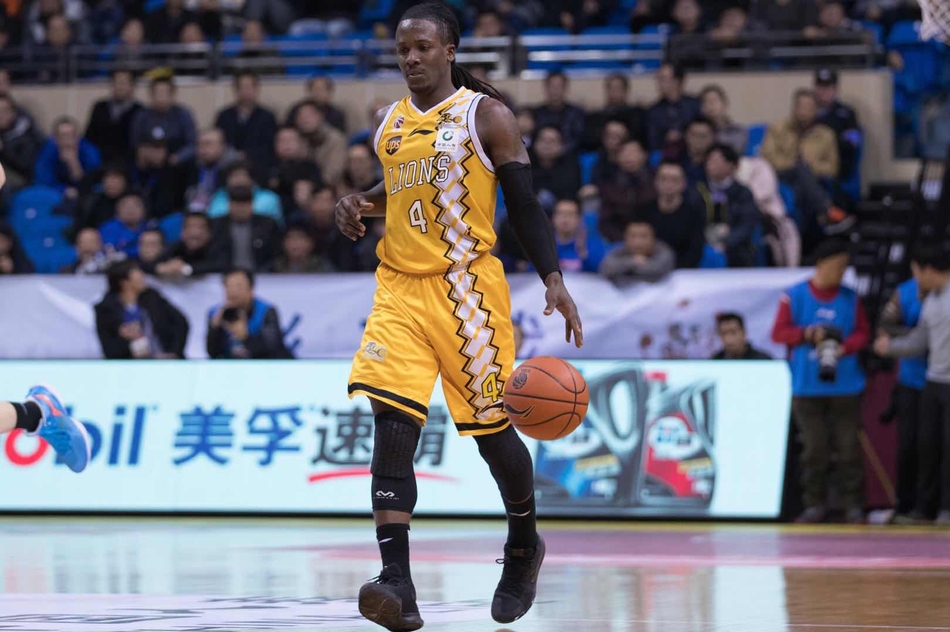 广厦队李京龙在底角命中外线三分后,右手握拳高举,脸上洋溢着兴奋的笑容,身旁的江苏队防守球员面露无奈之色。