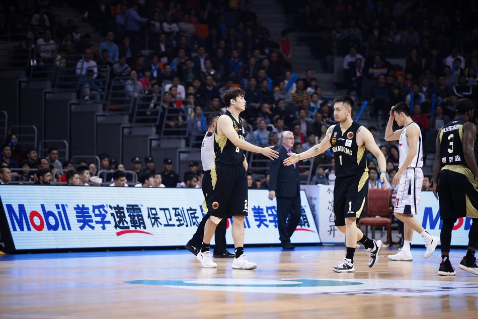 山东队核心丁彦雨航持球强行突破国家队老大哥周鹏的严防死守,两人肌肉碰撞,眼神中充满了对胜利的渴望,仿佛整个球场都成为他们的角斗场。