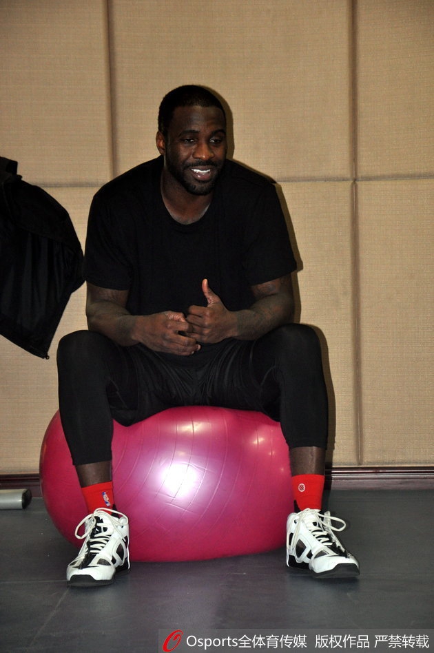 训练馆内灯火通明,泰·劳森身披山东高速战袍,刚刚归队的他与丁彦雨航并肩坐在场边的广告牌上,两人相视而笑,丁彦雨航一边比划一边说着什么,劳森则认真倾听,眼神中满是默契与坚定。