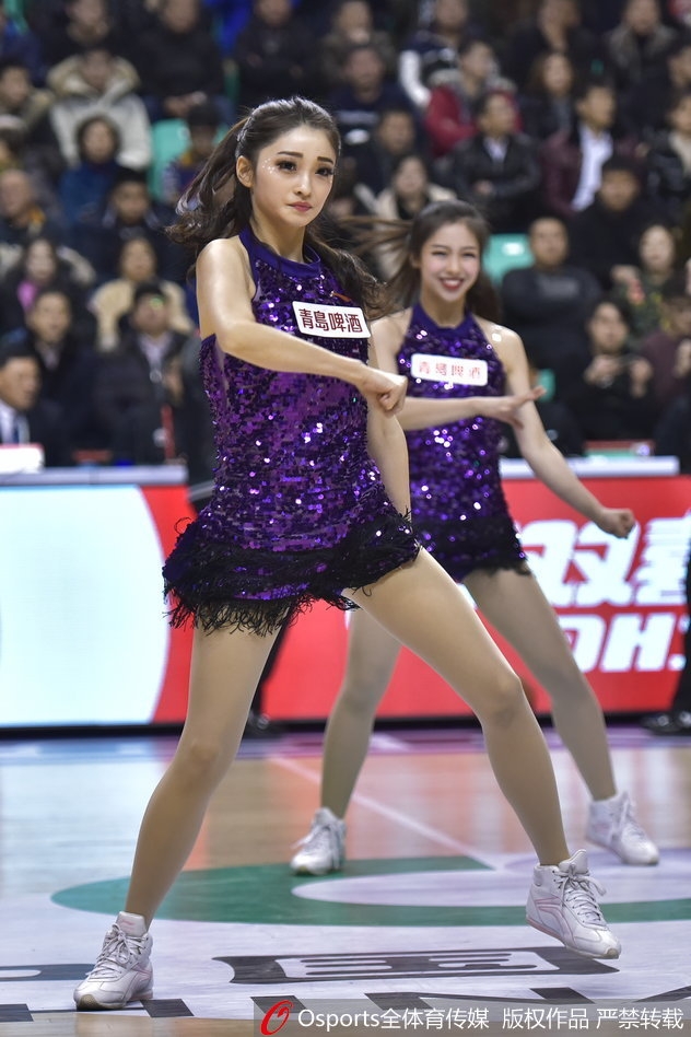 辽宁啦啦队宝贝身披白色绒衣在场边热身,回眸瞬间眼神灵动,带着羞涩而甜美的笑容,仿佛冰雪中绽放的玫瑰,为即将到来的热舞积蓄能量。