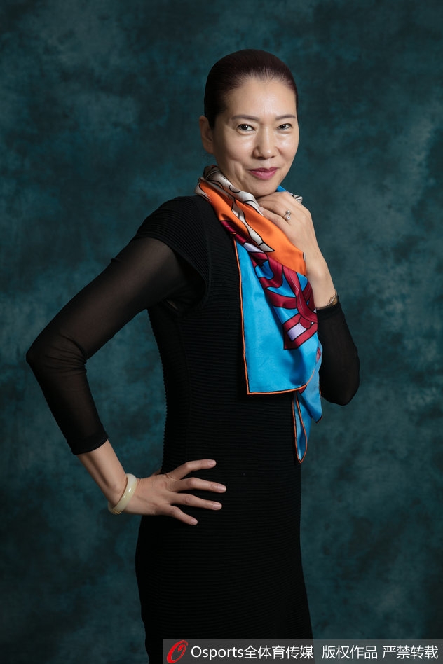 北区明星队后卫王丽丽眼神如炬，单手稳稳托住篮球，深色的训练服勾勒出她矫健的臂膀线条，仿佛下一秒就要冲破画面的束缚，将赛场上的凌厉气势带到了镜头前。