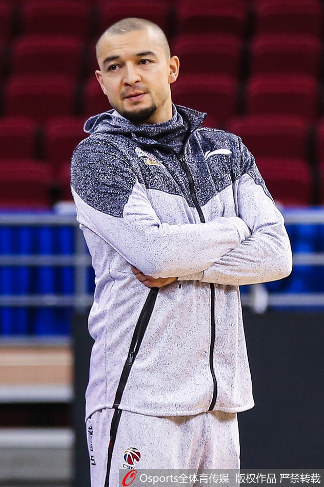 西热力江低头专注地系着鞋带,额头上的汗水诉说着训练的刻苦,红色的训练服映衬出他内心的火热与坚定