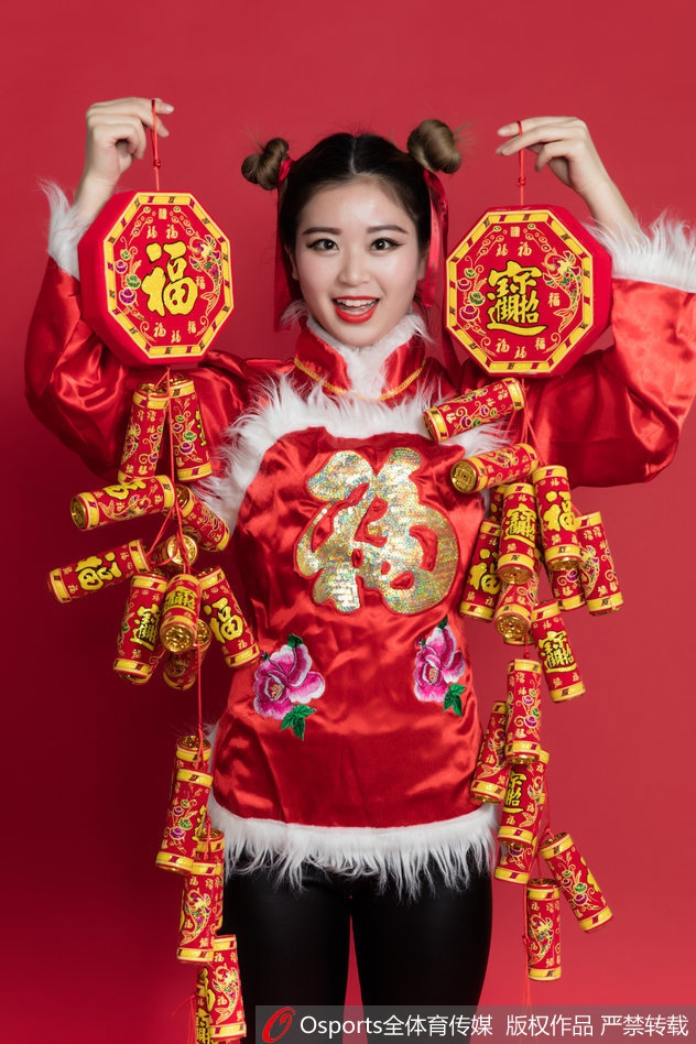 宝贝手持传统手绢花，眼神俏皮灵动，民俗服饰的精致纹样与青春面容相映成趣，传递出浓浓的年味与喜乐。