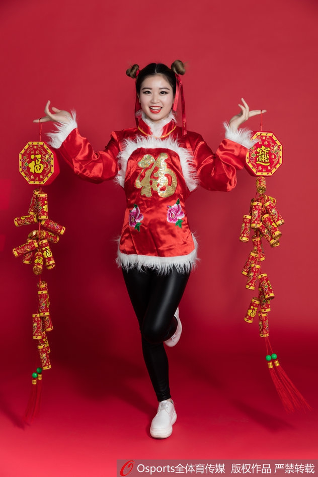 盛装打扮的篮球宝贝侧身回眸，中国红的上衣与精致的妆容在光影下格外明艳，展现了古典与现代交织的独特气质。