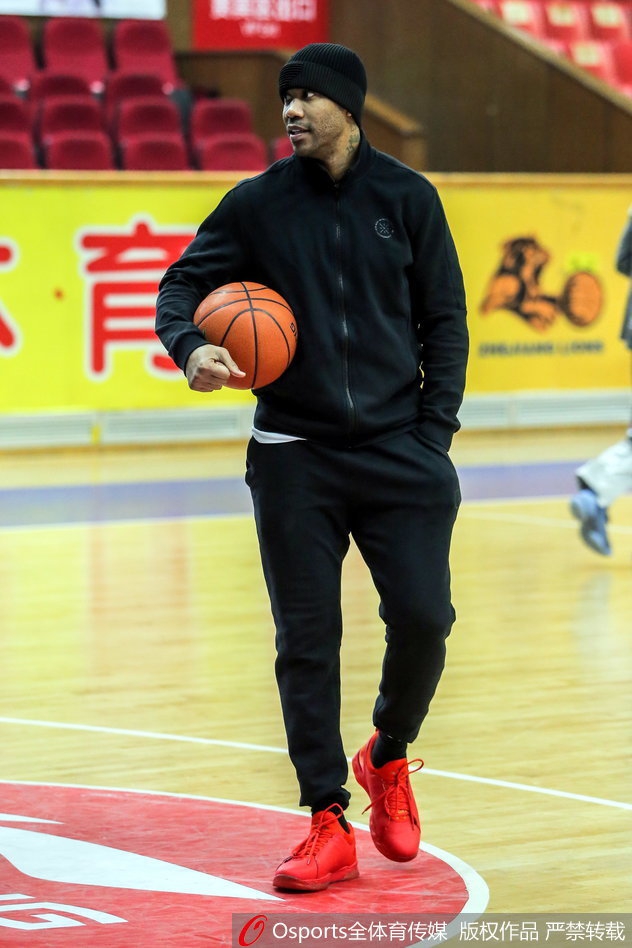 马布里单手抓球,眼神坚毅地望向篮筐,身旁的新外援正全神贯注地聆听这位CBA传奇的现场指导,空气中弥漫着专注与信任的气息。