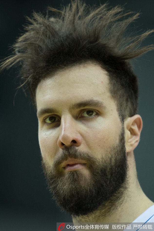 一位球员在激烈对抗中失去重心，身体倾斜45度却依然将球艰难传出，身后的队友则一脸惊讶地张开双手准备接应。