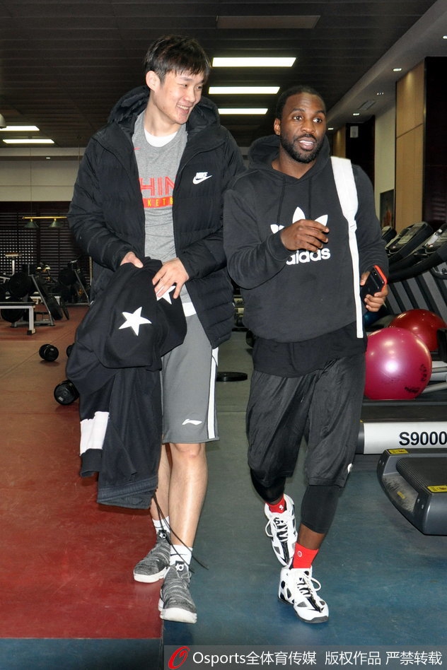 丁彦雨航在罚球线附近跳投出手,他高高跃起,滞空能力惊人。身后的训练背景虚化,更凸显了他作为球队核心的领袖气质,这一投也引来了场边队友的注视。