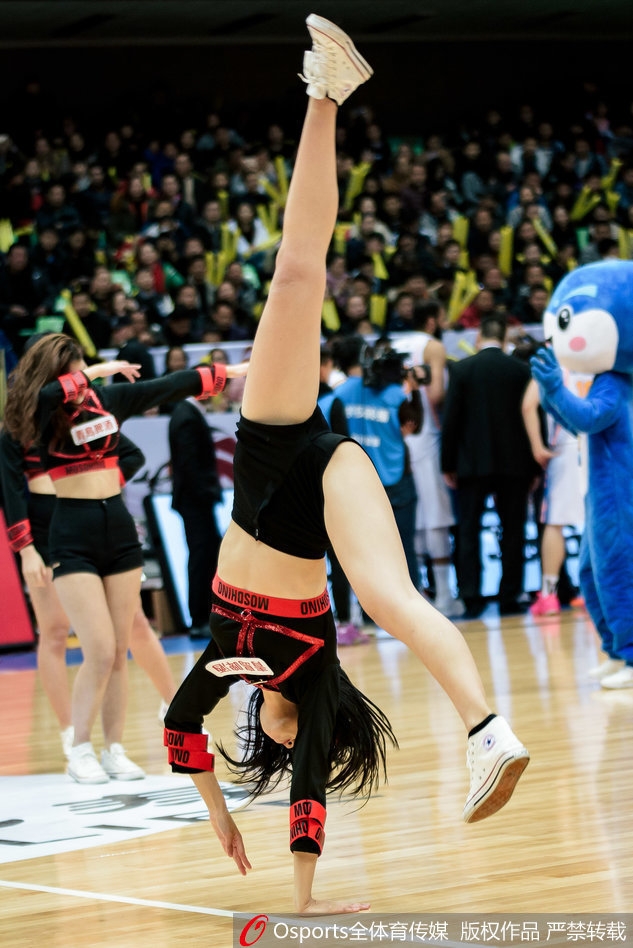 即使是在寒冷的冬季，篮球宝贝依然身着单薄表演服，在聚光灯下全神贯注地舞动，敬业精神令人动容