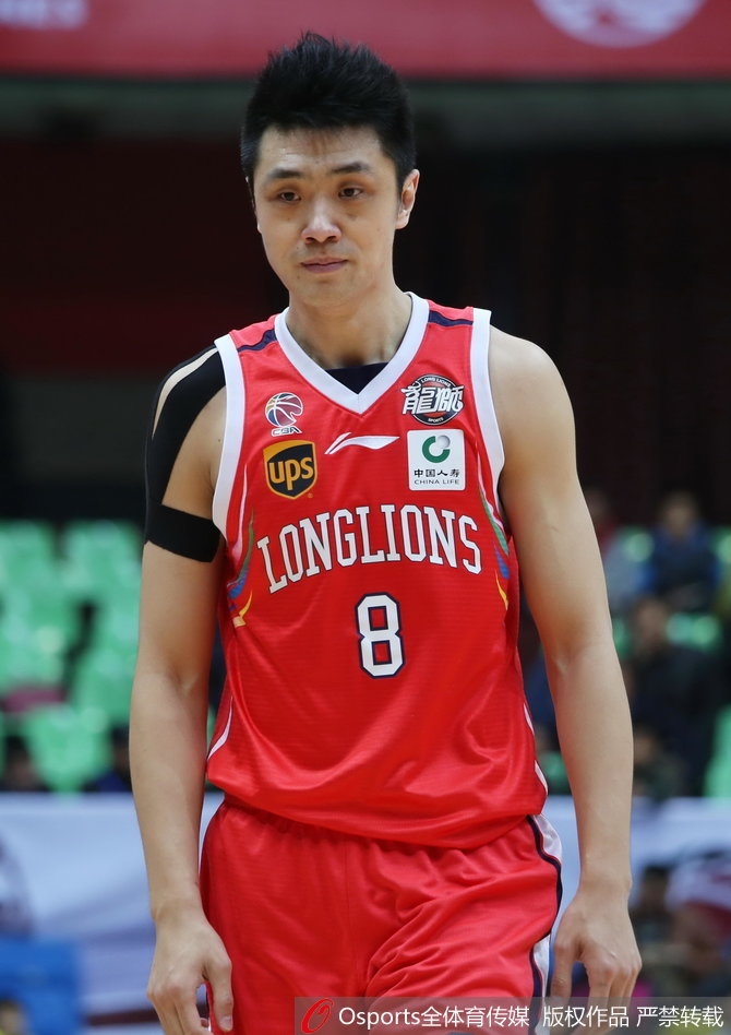 裁判在全神贯注地执法，将球交给罚球线上的球员，而球员身后则是密密麻麻、情绪高涨的现场观众。