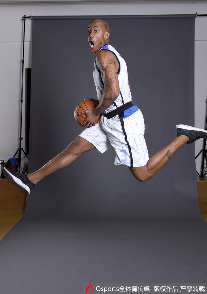 马布里与一群北京孩子在一起,他弯下腰,亲切地拍着一个孩子的头,孩子们围着他笑逐颜开,画面温暖动人,传递着篮球未来的希望。