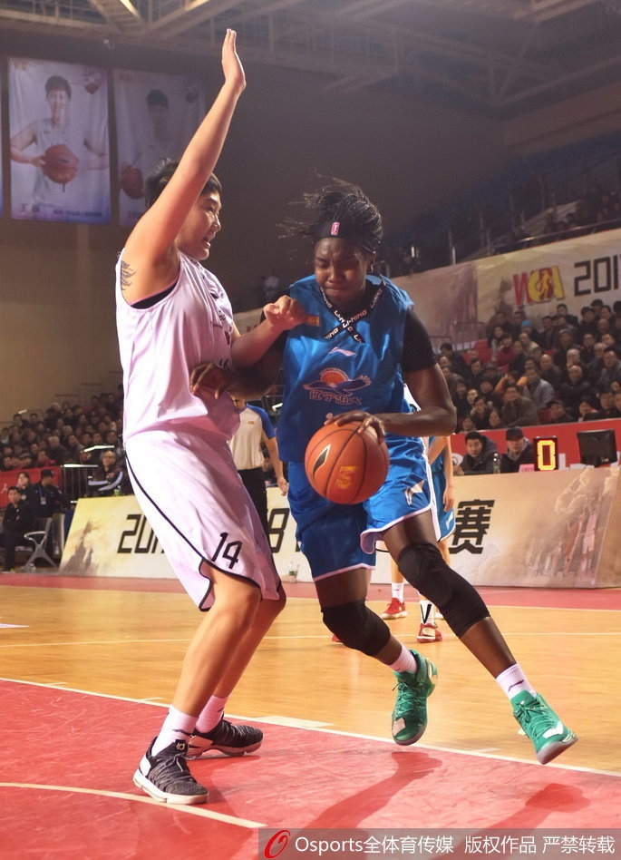 辽宁队球员在严密防守下强行出手，身体在空中失去平衡，依然奋力将球投向篮筐。