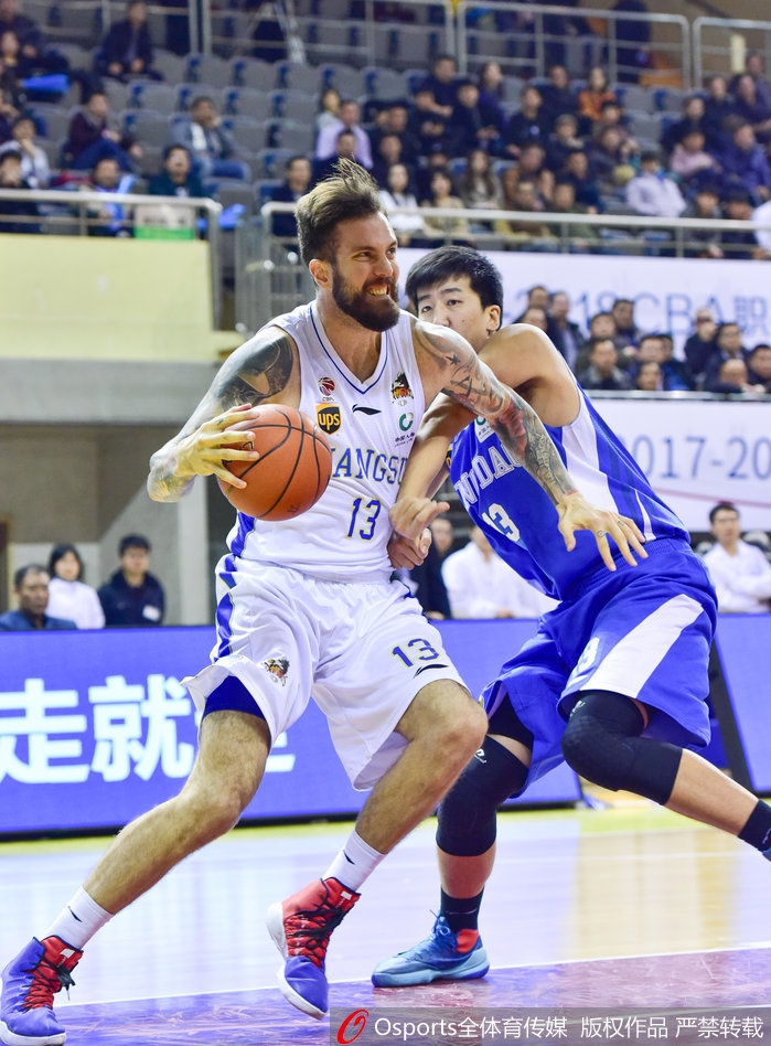 江苏队老将易立持球加速突破，他的身影矫健如风，虽然不再年轻，但每一次冲击篮筐都带着必胜的决心和领袖的担当。