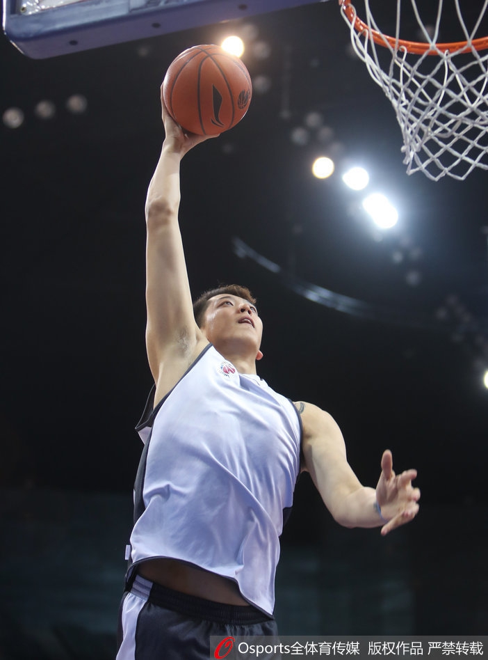 吴庆龙指导双手抱胸站在场边，眉头微蹙，正在仔细观察队员们的战术跑位，他的表情严肃而充满思考。