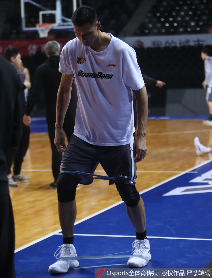 易建联在进行拉伸,身体舒展,肌肉线条流畅,展现了顶级运动员出色的身体柔韧性和协调性