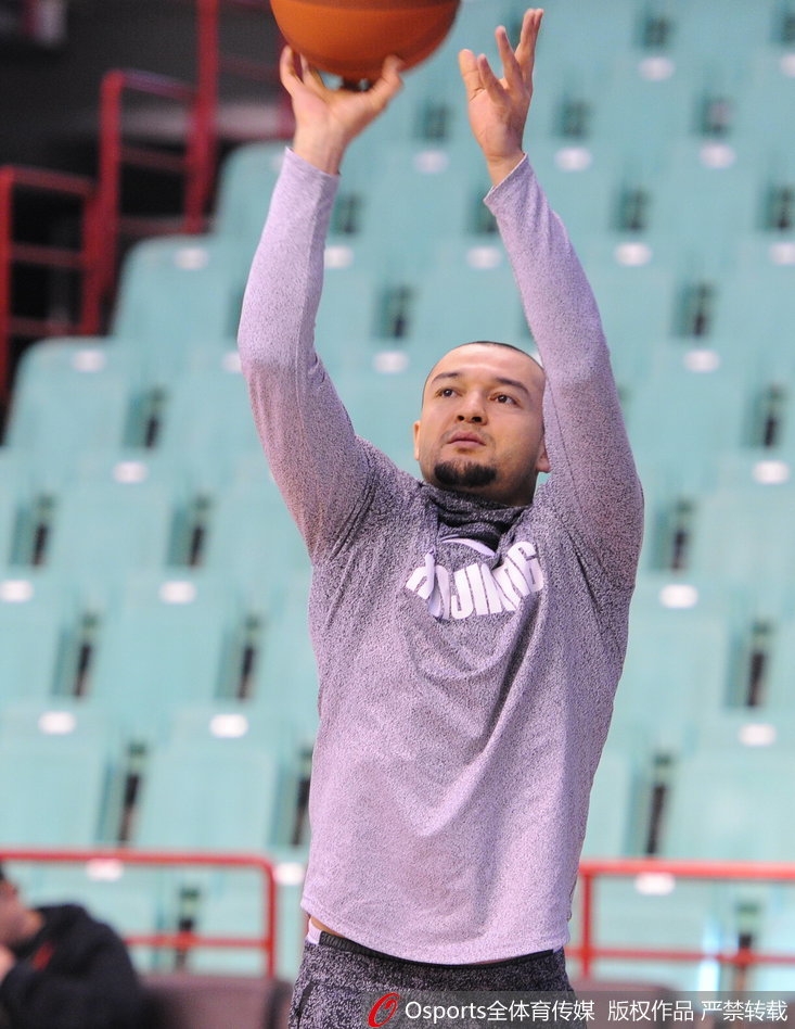 亚当斯微微侧身，用手指向远处，似乎在向哈德森讲述着什么有趣的往事；哈德森则双手叉腰，认真倾听，两人身后的看台坐满了等待比赛开始的球迷。