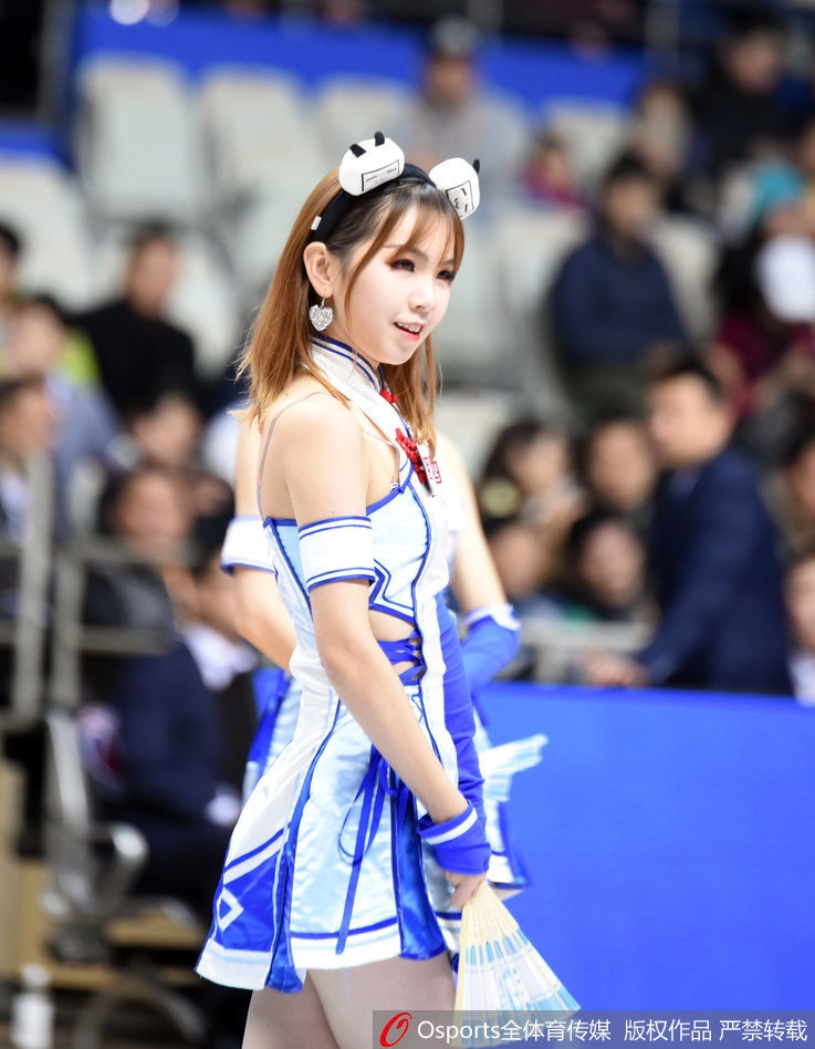 表演结束，女孩对着镜头送出飞吻，微微倾斜的身体和俏皮的表情充满了感染力。背景里模糊的看台和灯光，仿佛都在为这一刻的可爱定格做陪衬。