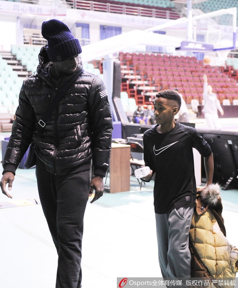 巴斯单手将儿子高高举起,让他摸高,父子俩笑容灿烂