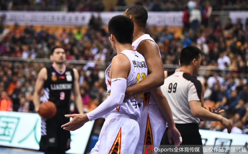 裁判员站在两人中间试图分隔开对峙的郭艾伦和于德豪，周围的球员们表情各异，有的拉架，有的观望，场面一度十分混乱。