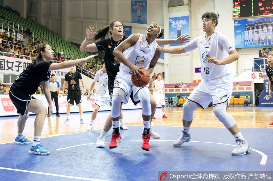 广东队外援约翰逊在三人包夹下强行上篮,她肌肉紧绷,表情坚毅,篮球在空中划过一道弧线,防守球员的手掌几乎封到了她的脸上,展现出极强的个人能力和对抗中的冷静。