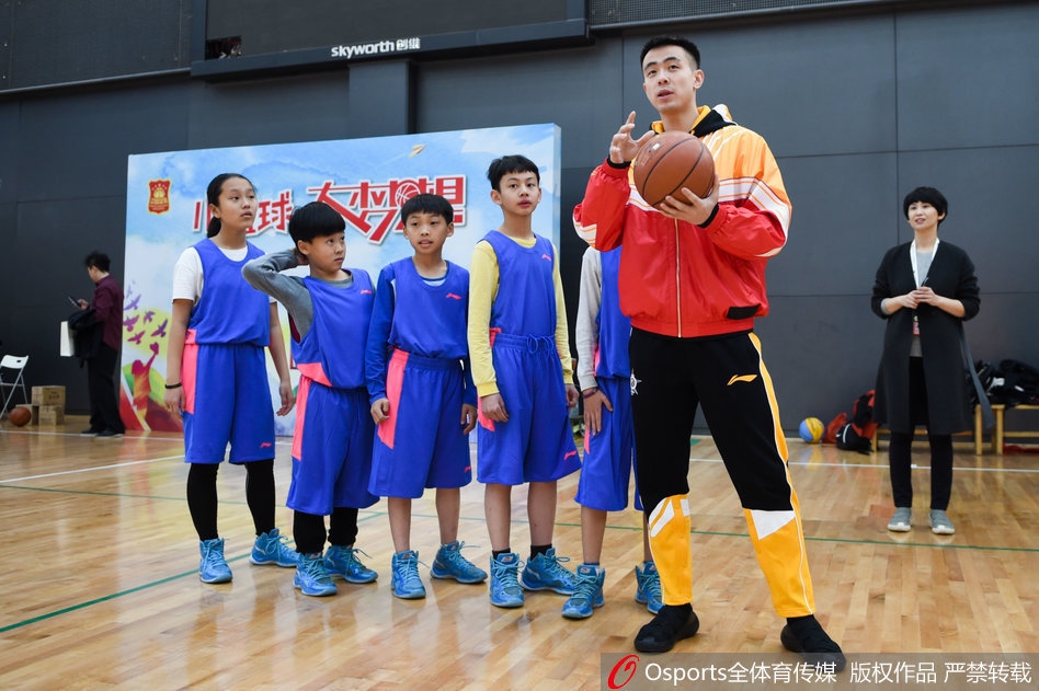 赵继伟面带温暖笑容，弯腰耐心地纠正着小球员的运球手型，小球迷眼神专注，完全沉浸在巨星的指导中。