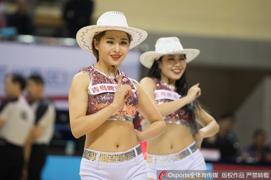 一位篮球宝贝高高跃起，手中的扇子在空中划出一道优美的弧线。她的表情欢快而富有感染力，将中国风元素完美融入了激情四射的篮球赛场。