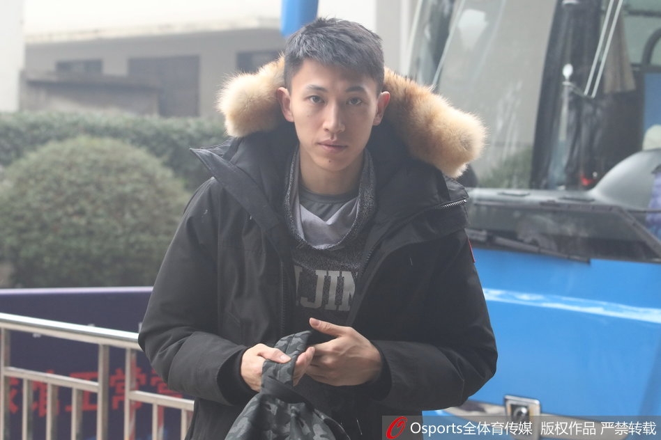 北京首钢男篮全体队员在教练组指挥下，正围绕中圈进行赛前拉伸训练，大家神情专注，气氛严肃而充满斗志