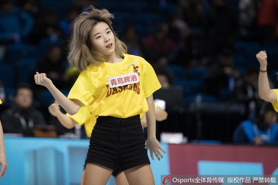 同曦主场灯光璀璨，篮球宝贝们身着亮黄色动感短裙，伴随着劲爆的音乐跃向空中，她们整齐划一的马尾辫和灿烂的笑容瞬间点燃了全场观众的激情。