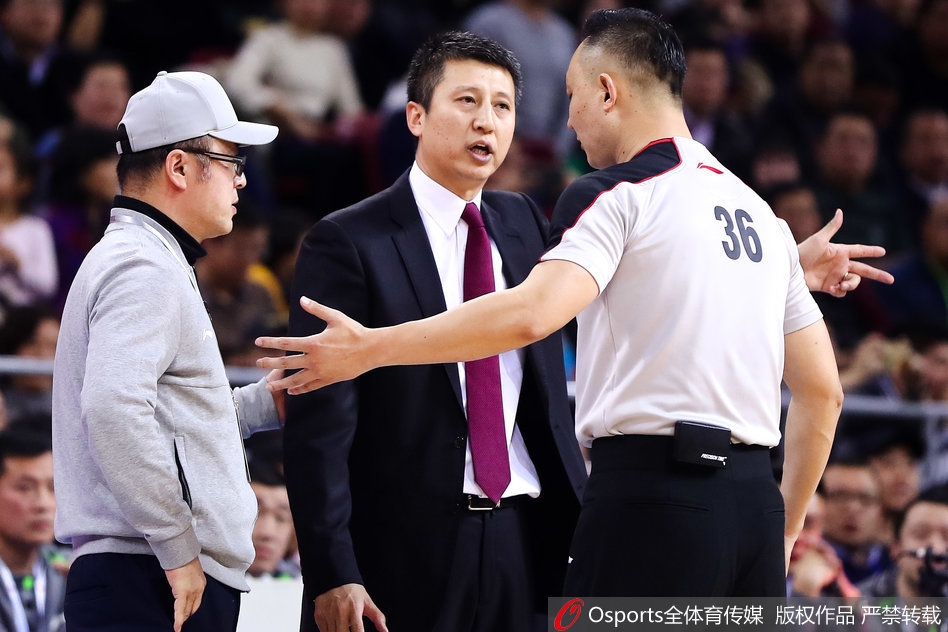 在嘈杂的首钢体育馆内，郭士强双手插兜，目光如炬地注视着裁判。他不再咆哮，但那份沉默中蕴含的力量更令人动容。辽宁队员哈德森站在一旁，神情略显无奈，师徒二人在这一刻共同承受着比赛带来的压力与不公。