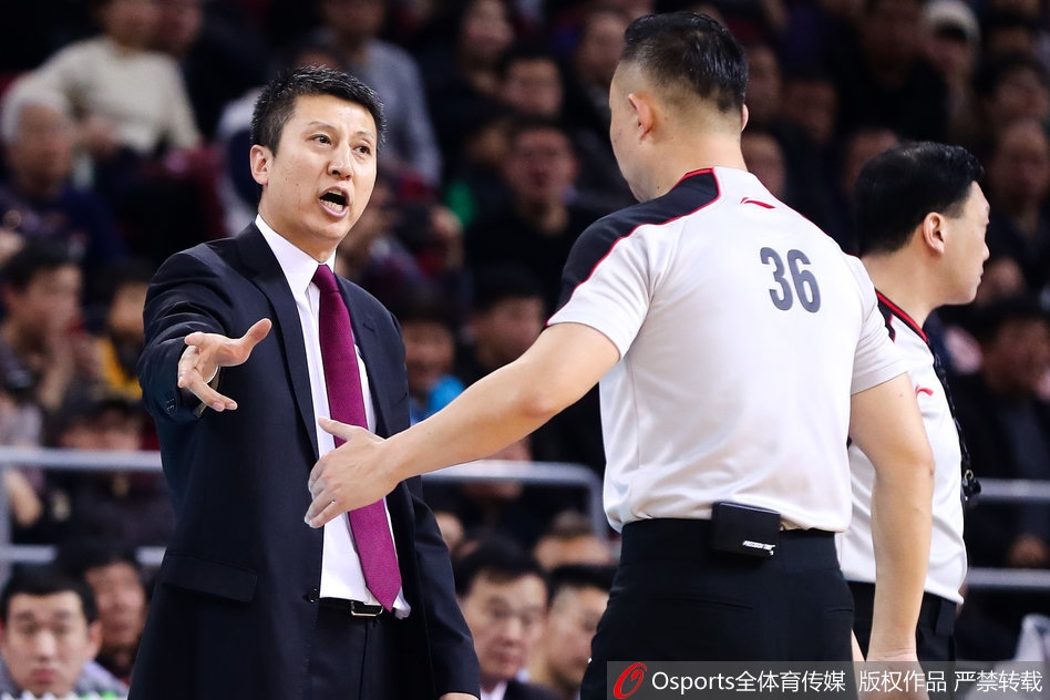 郭士强在场边摊开双手，脸上写满了无奈与愤怒。他的目光紧盯着裁判，似乎在质问：'为什么要这样吹罚？' 身后的辽宁球迷表情同样错愕，整个体育馆仿佛在这一刻凝固，所有人的目光都聚焦在这场无声的对峙上。
