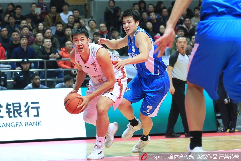 八一队球员雷蒙在青岛队防守球员的严密贴身干扰下,依然眼神坚定,高高跃起上演高难度跳投。