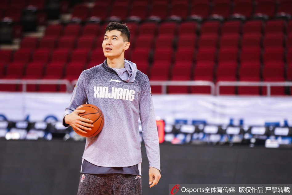 西热力江在助教的协助下进行拉伸训练,肌肉线条分明,神情专注而放松,展现了职业球员对身体管理的极致追求