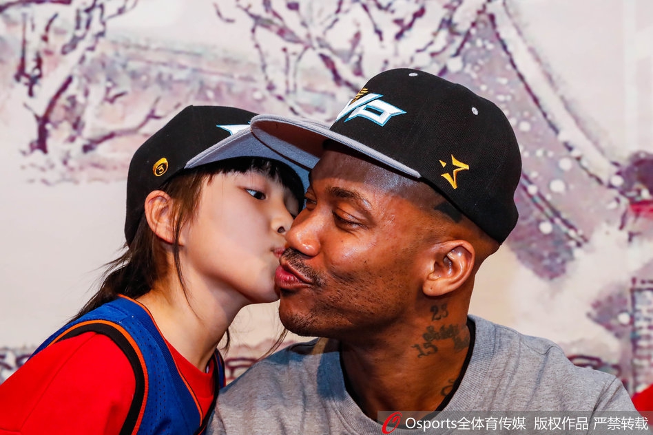 人潮涌动的见面会现场，身着红色卫衣的小球迷踮起脚尖，用小手捧着马布里的脸，献上了一个纯真而深情的吻，老马闭眼弯腰，满是胡茬的脸上露出慈祥的笑容，仿佛瞬间被这个吻融化了心。