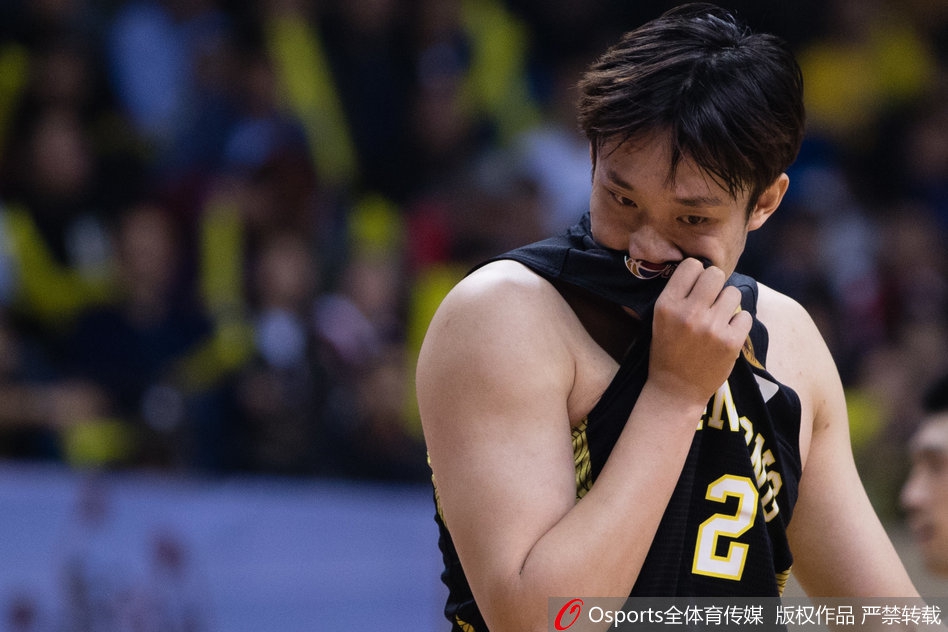 篮下激烈对抗中，丁彦雨航在江苏内线球员的合围下拼抢进攻篮板，他肌肉紧绷，奋力将球拨向自己。