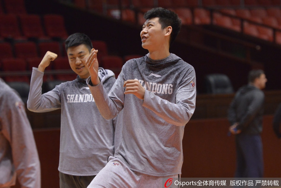 看到丁彦雨航的滑稽表演，场边的队友们彻底放弃了矜持，有的笑得前仰后合，有的则用手指着小丁，仿佛在说：'你这家伙，还有多少惊喜是我们不知道的？'整个球馆充满了快活的空气。