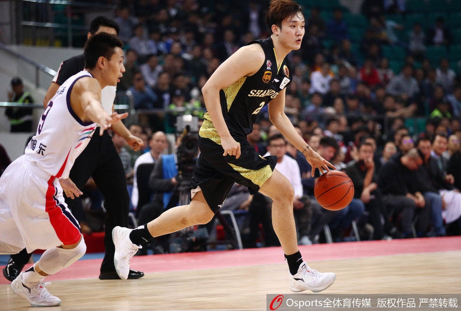 山东队外援劳森在多人围堵下艰难上篮，身体失去平衡，展现比赛的激烈对抗程度。