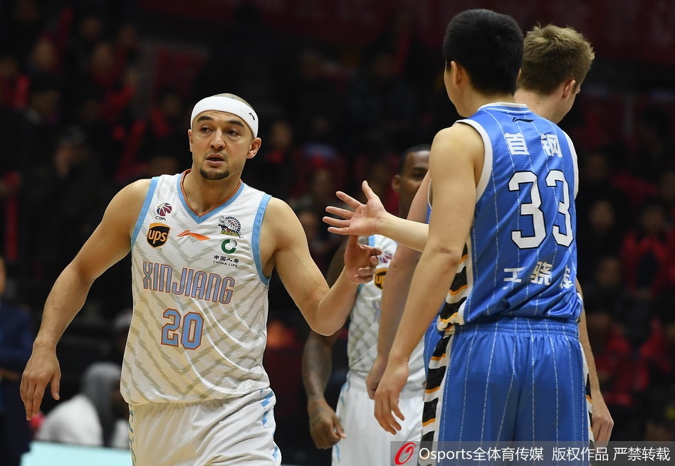 新疆队小外援达柳斯-亚当斯如闪电般突破北京队的双层防线,他眼神坚毅,在两人夹击的缝隙中寻找上篮的机会。