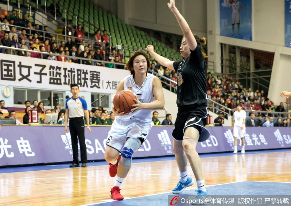 暂停期间,江苏队主教练手持战术板,半蹲在球员中间,用笔在板上飞快地画着战术,队员们围成一圈聚精会神地聆听,眼神中充满了对胜利的渴望和对教练的信任。